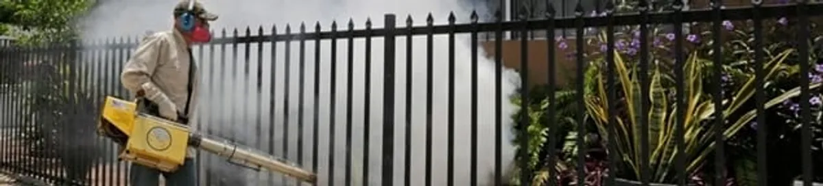 Mosquito control technician fogging a yard perimeter for mosquito reduction in Tallahassee, FL